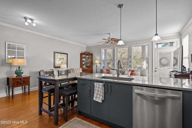 kitchen with sink, dark wood-type flooring, dishwasher, hanging light fixtures, and ornamental molding