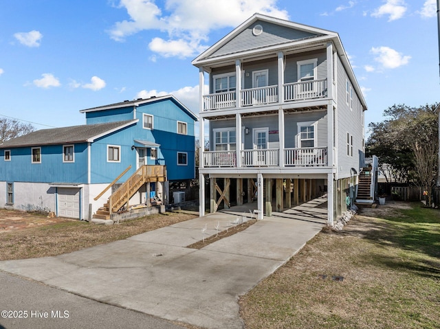 coastal inspired home with central AC, a carport, a balcony, and covered porch