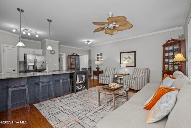 living room with hardwood / wood-style flooring, ornamental molding, and ceiling fan