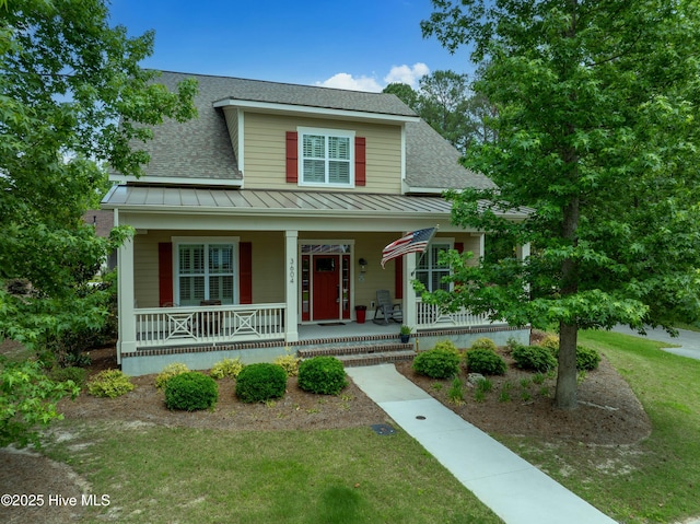 3604 Haughton Ln, Castle Hayne, NC 28429 - view of front facade featuring a standing seam roof, a shingled roof, covered porch, metal roof, and a front yard