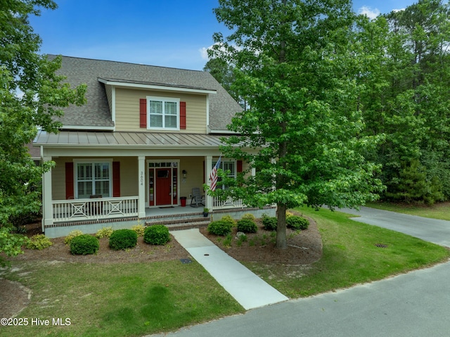 3604 Haughton Ln, Castle Hayne, NC 28429 - view of front of property with a standing seam roof, a shingled roof, a porch, a front yard, and metal roof