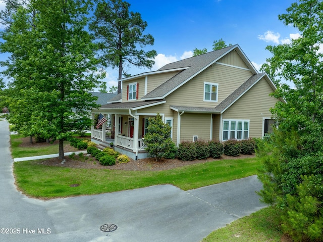 3604 Haughton Ln, Castle Hayne, NC 28429 - view of front facade with covered porch, a shingled roof, and a front yard