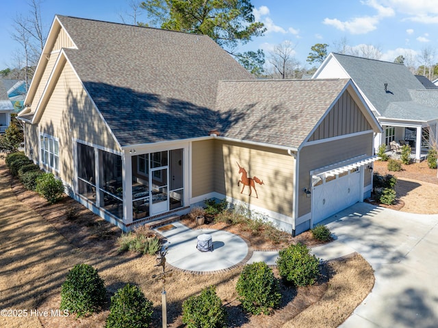 3604 Haughton Ln, Castle Hayne, NC 28429 - view of front of property featuring a sunroom, a shingled roof, board and batten siding, a garage, and concrete driveway