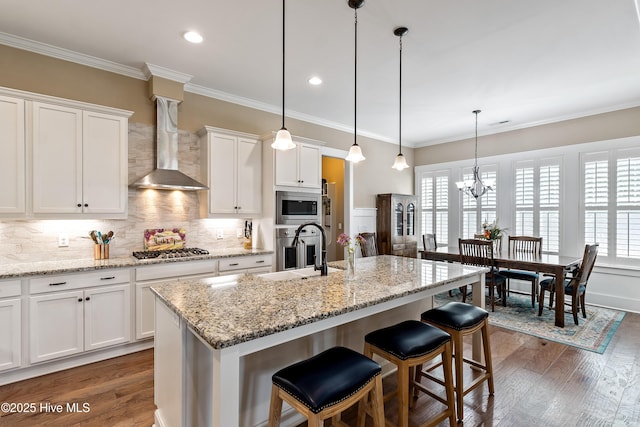 3604 Haughton Ln, Castle Hayne, NC 28429 - kitchen with appliances with stainless steel finishes, wall chimney exhaust hood, a sink, a breakfast bar area, and white cabinetry