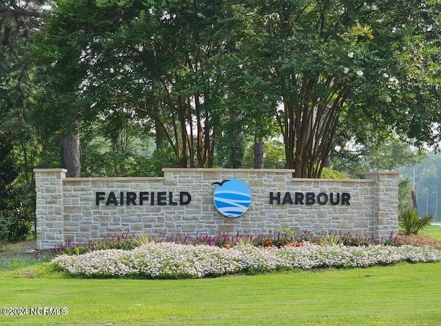 community / neighborhood sign featuring a lawn