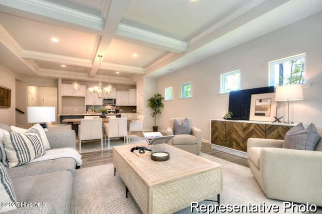 living room with beamed ceiling, coffered ceiling, an inviting chandelier, and light hardwood / wood-style flooring