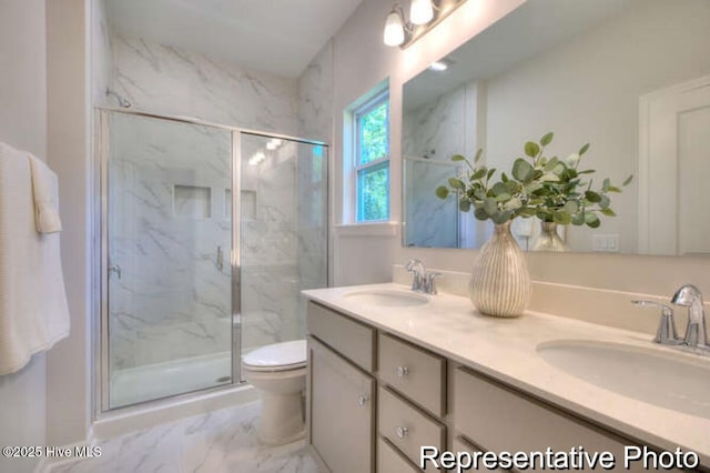 bathroom with vanity, a shower with shower door, and toilet