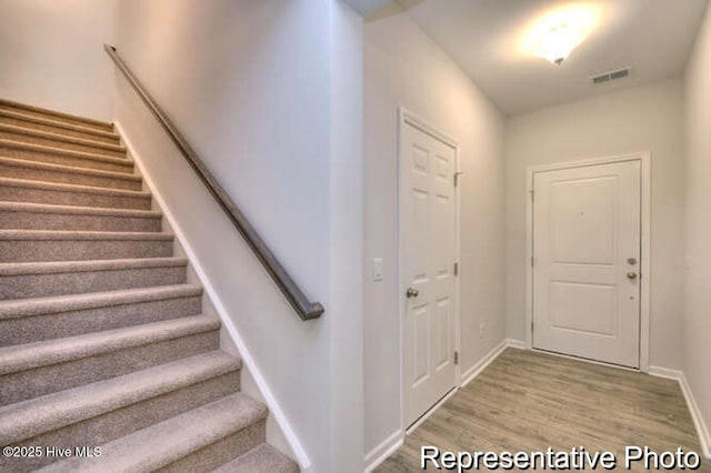 staircase featuring wood-type flooring