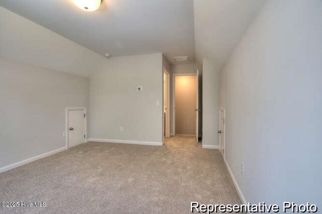 bonus room featuring lofted ceiling and light carpet