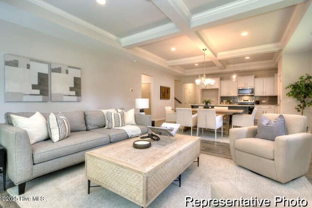 living room featuring coffered ceiling, a notable chandelier, crown molding, and beamed ceiling