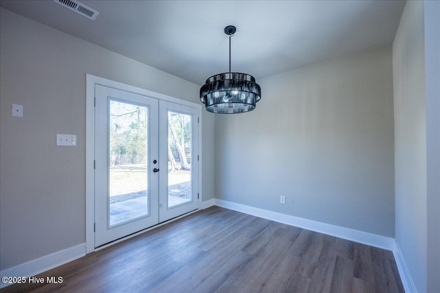 doorway featuring an inviting chandelier, dark hardwood / wood-style flooring, and french doors