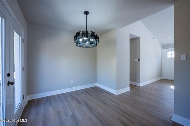 unfurnished dining area featuring hardwood / wood-style flooring and a notable chandelier