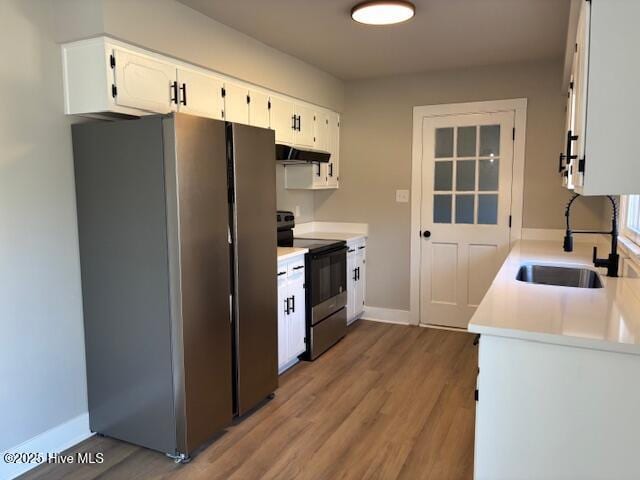 kitchen featuring sink, light hardwood / wood-style floors, white cabinets, and appliances with stainless steel finishes