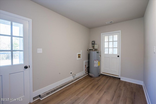 clothes washing area featuring hardwood / wood-style flooring, hookup for a washing machine, and electric water heater