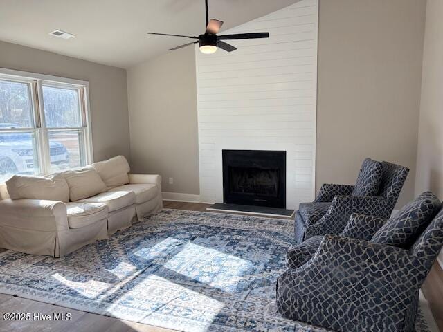 unfurnished living room featuring hardwood / wood-style flooring, a large fireplace, ceiling fan, and vaulted ceiling