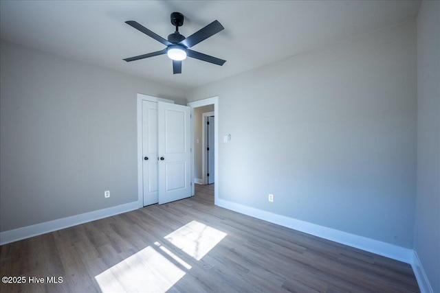 unfurnished bedroom featuring wood-type flooring, a closet, and ceiling fan