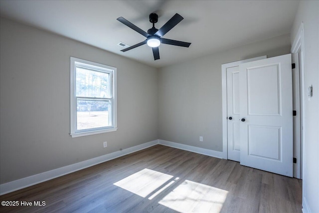 unfurnished bedroom featuring ceiling fan, light wood-type flooring, and a closet