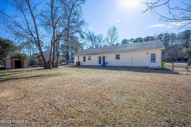 back of property with a yard and a shed