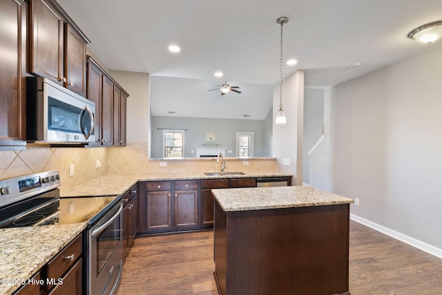 kitchen featuring appliances with stainless steel finishes, a sink, dark wood finished floors, and dark brown cabinets