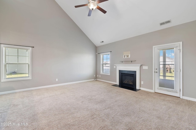 unfurnished living room featuring baseboards, a fireplace with flush hearth, visible vents, ceiling fan, and high vaulted ceiling