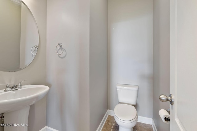 bathroom with tile patterned floors, toilet, and baseboards