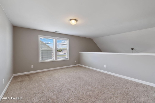 additional living space with visible vents, baseboards, vaulted ceiling, and carpet floors