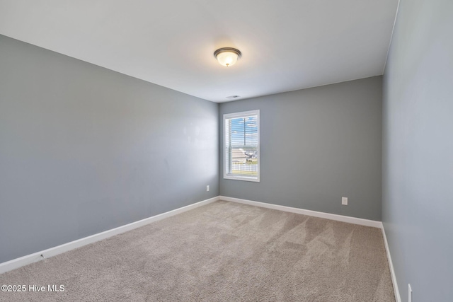 carpeted empty room with baseboards