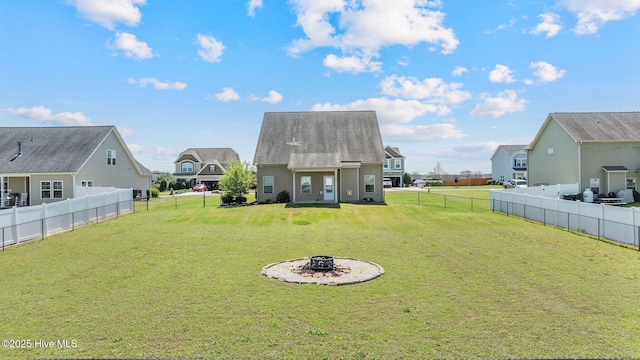 view of yard with a residential view, a fire pit, and a fenced backyard