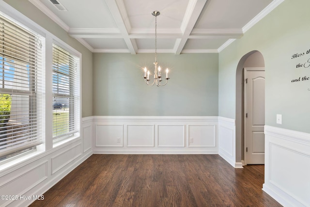 unfurnished dining area with arched walkways, plenty of natural light, dark wood-style floors, and beam ceiling