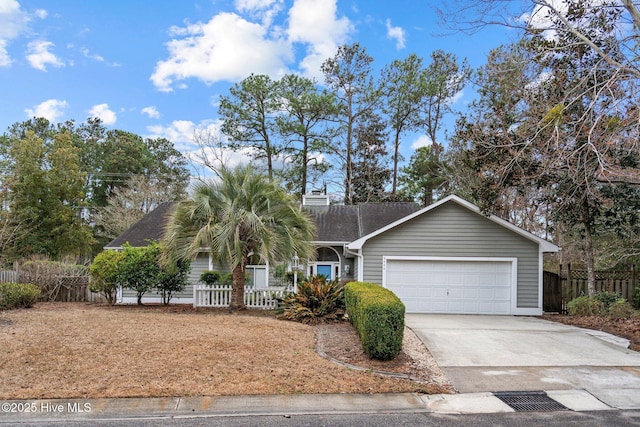 view of front facade featuring concrete driveway, a chimney, an attached garage, and fence