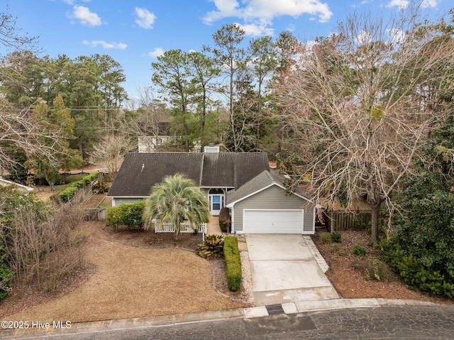 view of front of house with a shingled roof, driveway, a garage, and fence