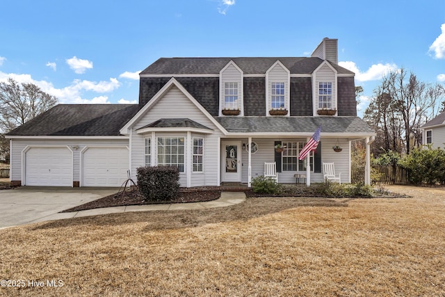 view of front of property featuring a garage, a front yard, and covered porch