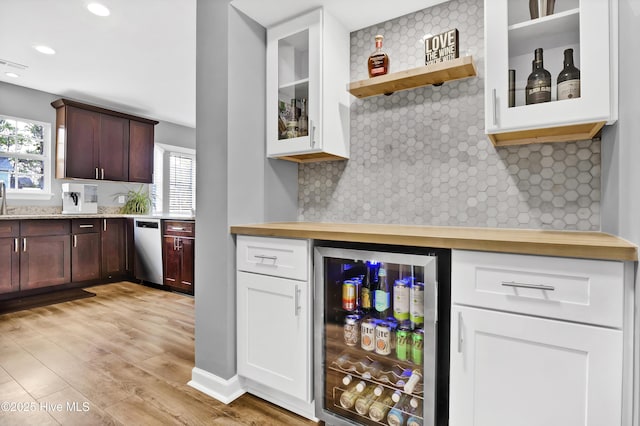 kitchen featuring dark brown cabinets, dishwasher, beverage cooler, light hardwood / wood-style floors, and decorative backsplash