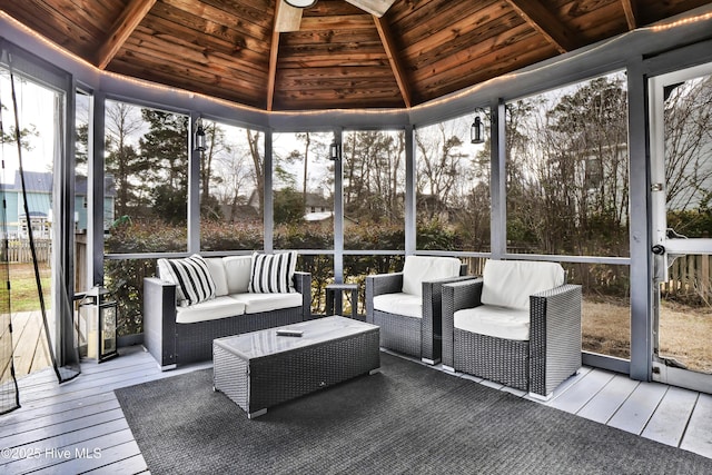 sunroom featuring vaulted ceiling, a healthy amount of sunlight, and wooden ceiling