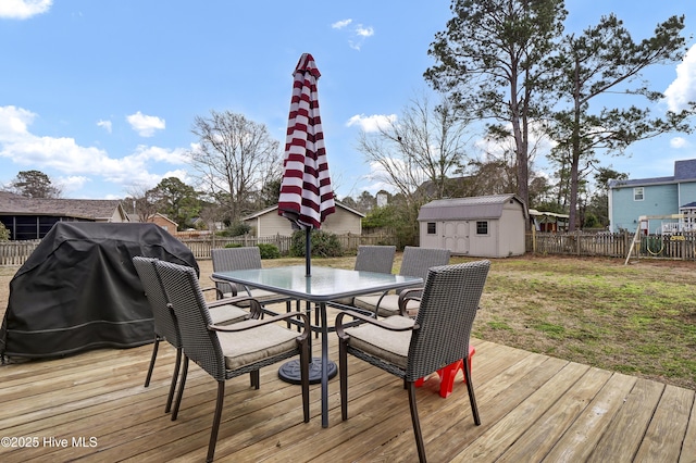 wooden deck featuring grilling area, a yard, and a shed