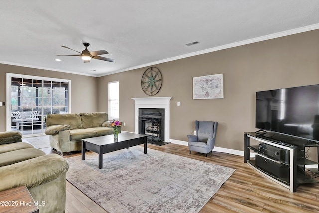 living room featuring crown molding, wood-type flooring, and ceiling fan