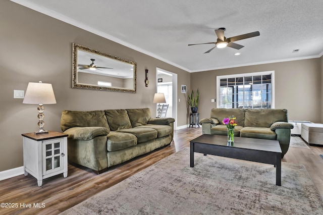 living room featuring ceiling fan, ornamental molding, dark hardwood / wood-style floors, and a textured ceiling