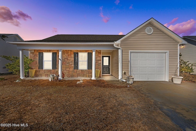 ranch-style home featuring a garage and covered porch