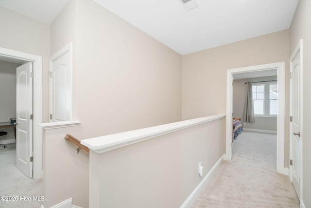 corridor featuring light colored carpet