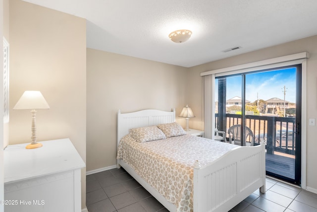 bedroom with access to exterior, tile patterned flooring, and a textured ceiling