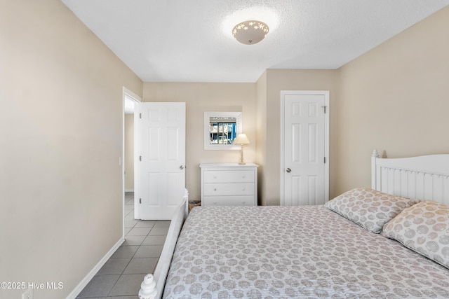 bedroom featuring tile patterned floors and a textured ceiling