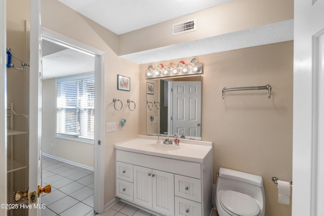 bathroom featuring tile patterned floors, vanity, toilet, and a textured ceiling