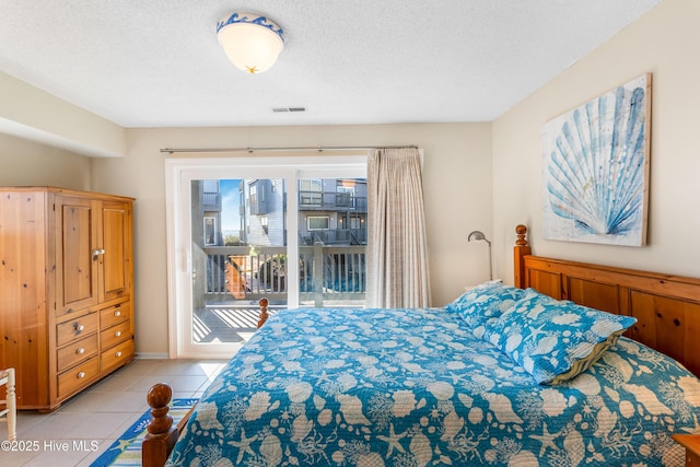 tiled bedroom featuring a textured ceiling and access to outside