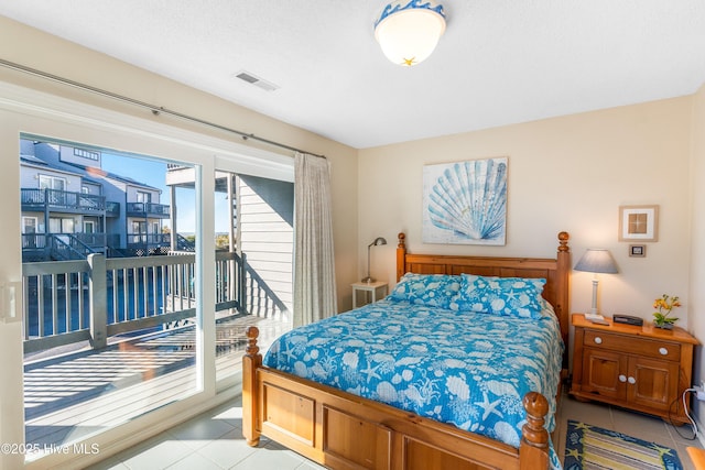 1928 New River Inlet Rd Unit 215, North Topsail Beach, NC 28460 - bedroom featuring a textured ceiling, access to outside, light tile patterned flooring, and visible vents