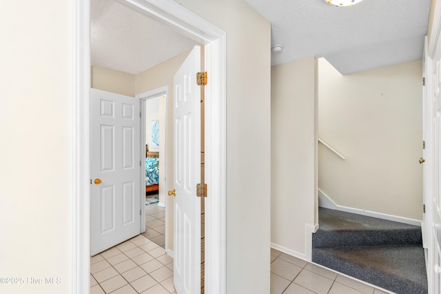 staircase featuring tile patterned floors and a textured ceiling