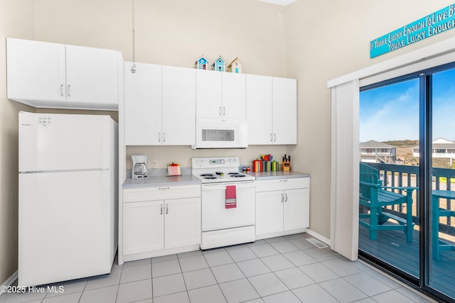 kitchen featuring white cabinetry, white appliances, and light tile patterned floors