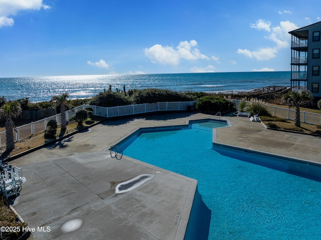 view of pool featuring a patio and a water view