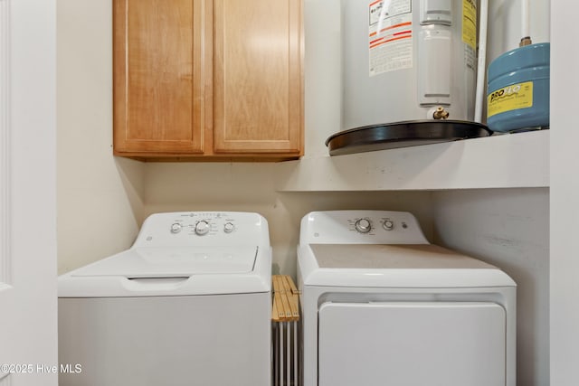 laundry area featuring cabinets, water heater, and washer and dryer