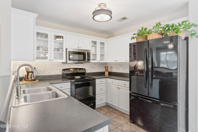 kitchen featuring white cabinetry, black appliances, sink, light tile patterned floors, and decorative backsplash