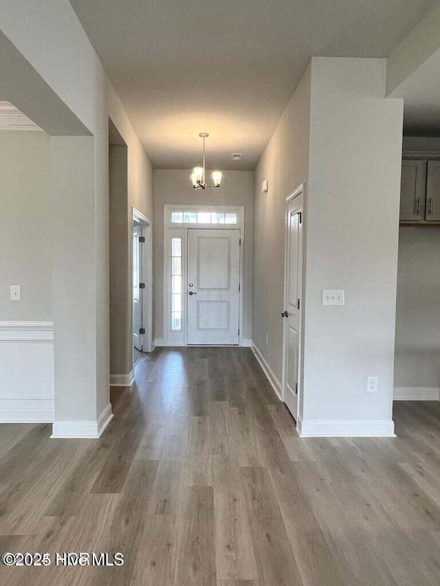 entryway with hardwood / wood-style flooring and an inviting chandelier